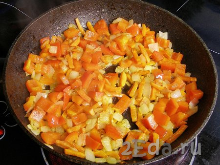 Нарезанный перец добавляем в сковороду с обжаренными морковкой и луком, перемешиваем. Обжариваем овощи 4-5 минут (до мягкости перца), иногда помешивая.
